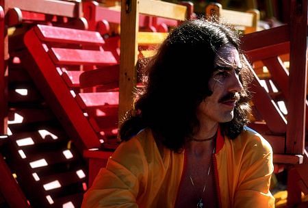 Profile of George Harrison in Acapulco posing near wooden lounge chairs January 1977