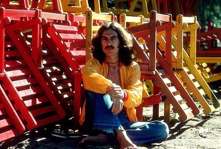 George Harrison posing with colorful wooden lounge chairs, January 1977