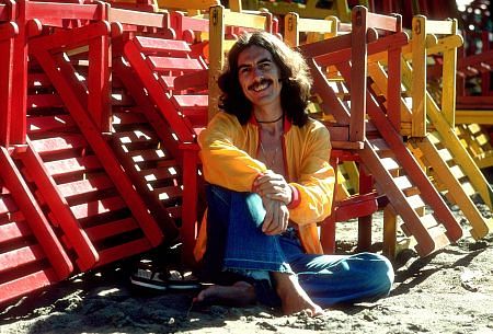 George Harrison in Acapulco posing with colorful wooden lounge chairs, January 1977