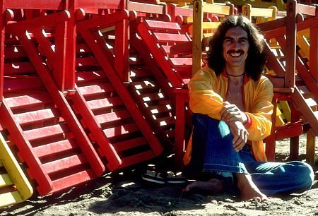 George Harrison in Acapulco posing with coloful wooden lounge chairs, January 1977