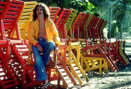 George Harrison in Acapulco posing with colorful wooden lounge chairs, January 1977