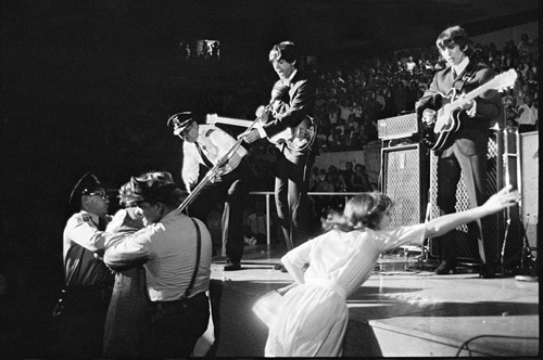 The Beatles' Paul McCartney and George Harrison performing live at a concert
