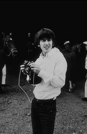 George Harrison with camera (Ringo Starr in background) in Ozarks. Arkansas, c. 1965