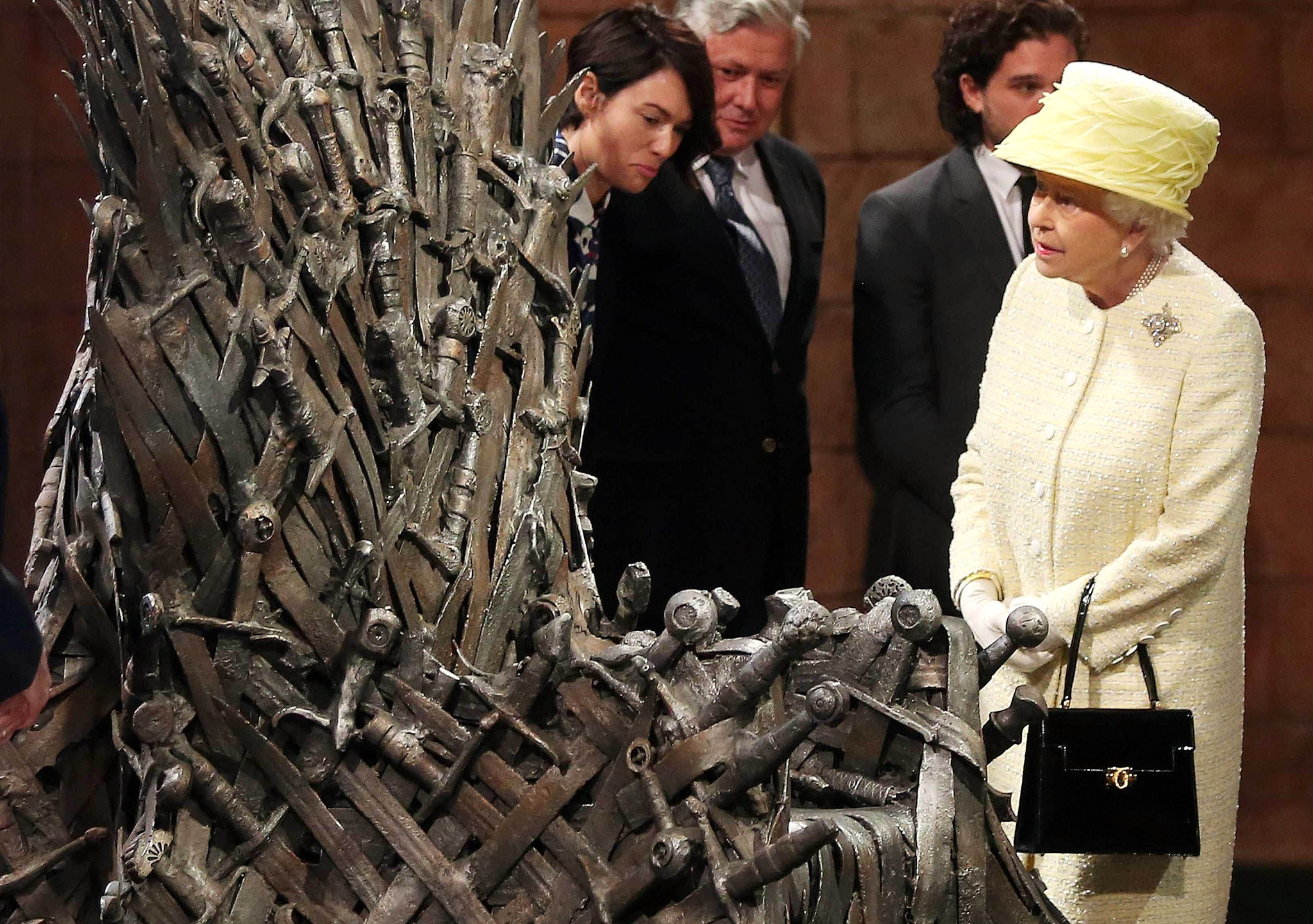 Queen Elizabeth II meets cast members of the HBO TV series 'Game of Thrones' Lena Headey and Conleth Hill as she views some of the props including the Iron Throne on set in Belfast's Titanic Quarter on June 24, 2014 in Belfast, Northern Ireland.