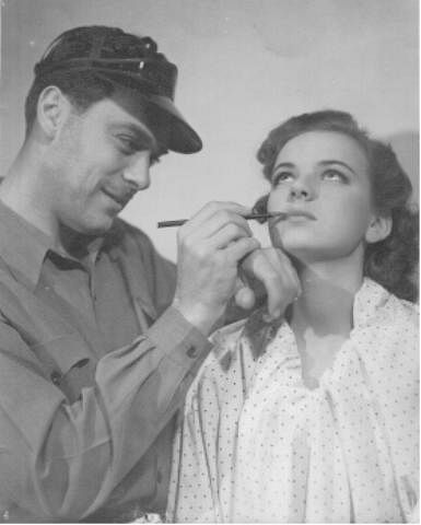 Louis Hippe applying makeup on Barbara Hippe, his daughter, at the studio.