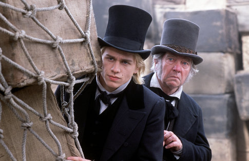 Nicholas Nickleby (CHARLIE HUNNAM) and Newman Noggs (TOM COURTENAY) keep an eye on mischief