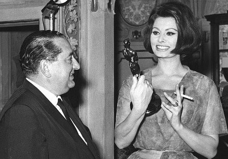 Sophia Loren shows Joseph Levine her Oscar in her home in Rome, Italy, c. 1961