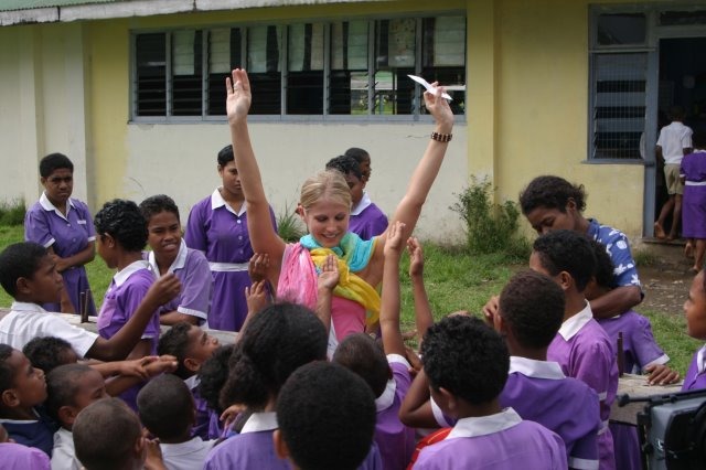 Fiji, pilot: Blue, handing out stickers to children at a local school