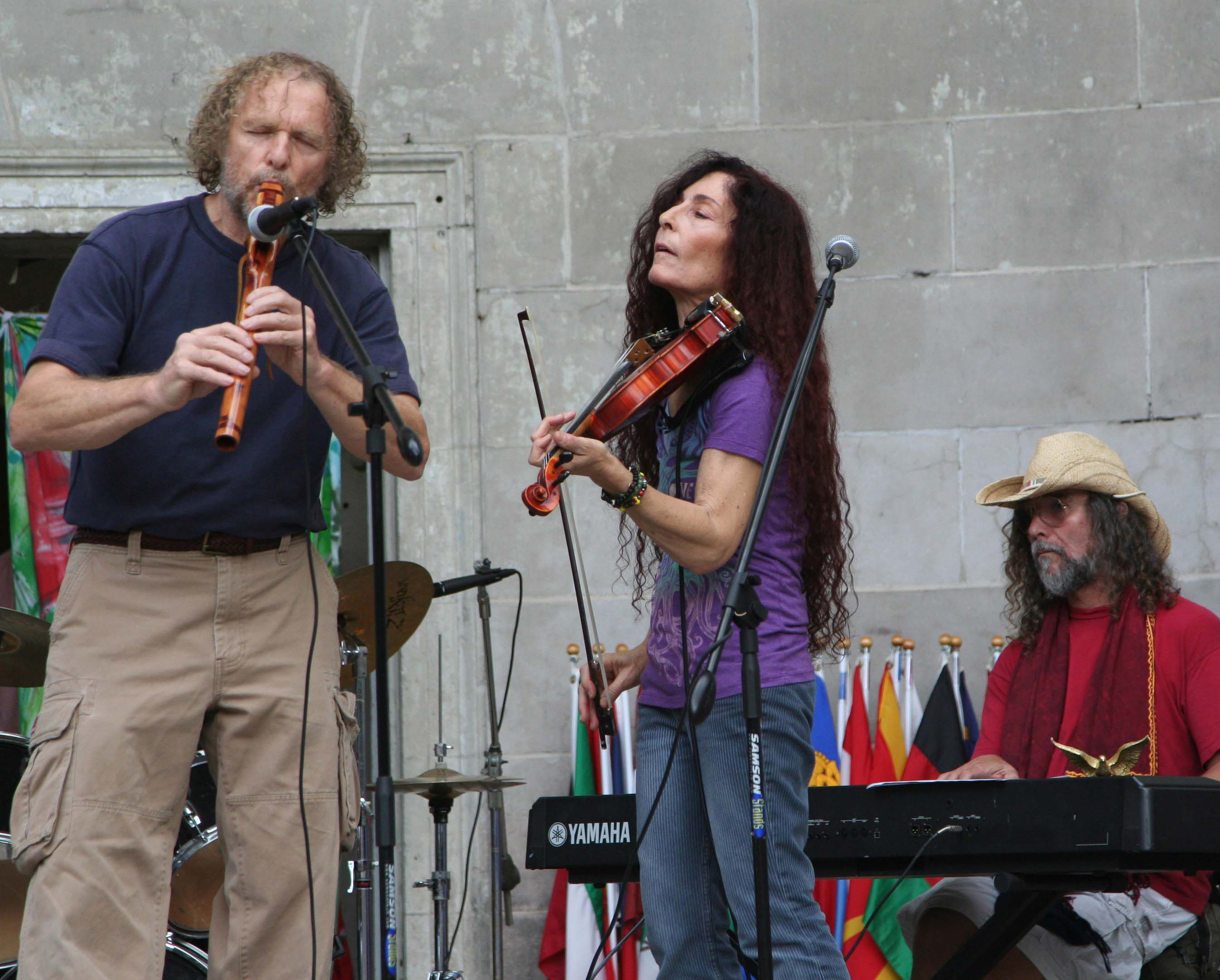 William Waterway playing Native American Flute as Sharon Benson looks on and Guillermo Silveira plays keyboard. Location: New York City at Central Park Bandshell. Event: United Nations' International Peace and Ecology Vigil.