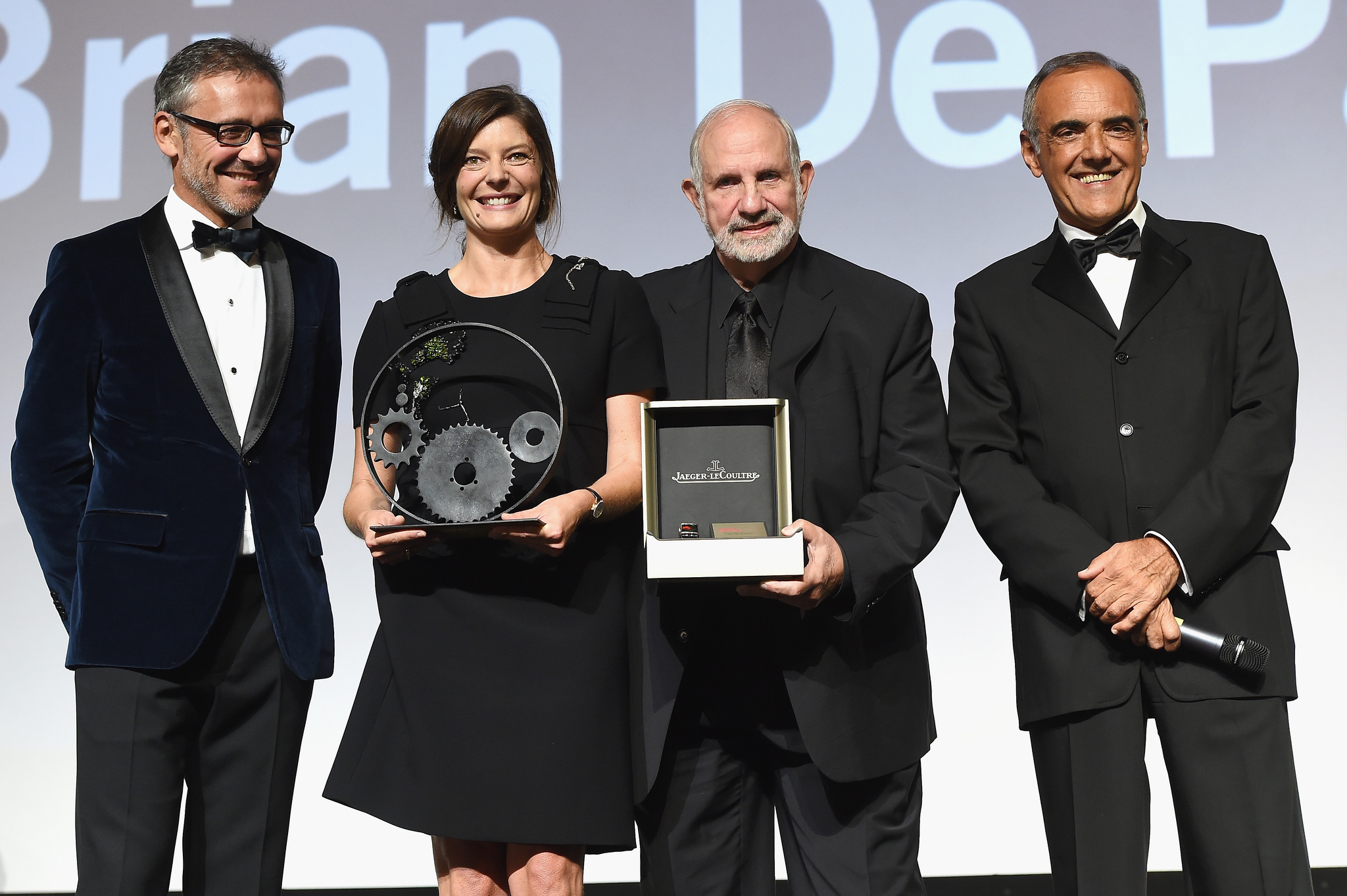 Chiara Mastroianni and Brian De Palma on stage with their awards with Laurent Vinay and Venice Film Festival director Alberto Barbera at the Jaeger-LeCoultre Glory to the Filmmaker 2015 Award Ceremony.