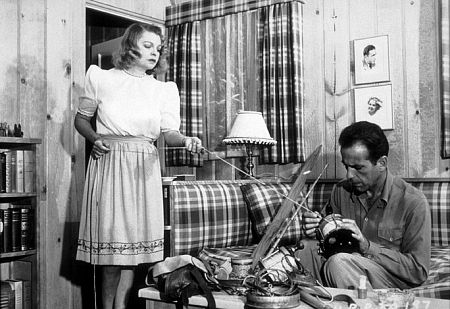 Humphrey Bogart cleaning his fishing tackle with his third wife, Mayo Methot, at home, circa 1944.