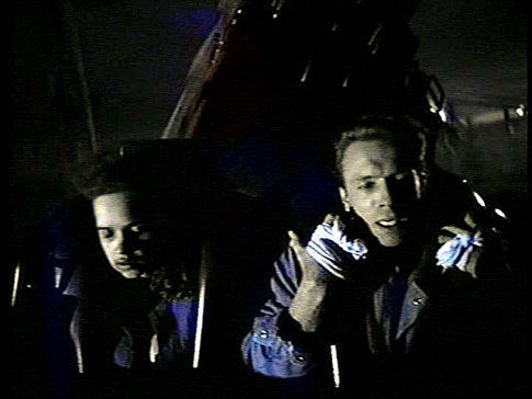Max (John Pyper-Ferguson) with Lori (Chantelle Jenkins) holds on tight to a runaway coaster in David Winning's KILLER IMAGE (1992)