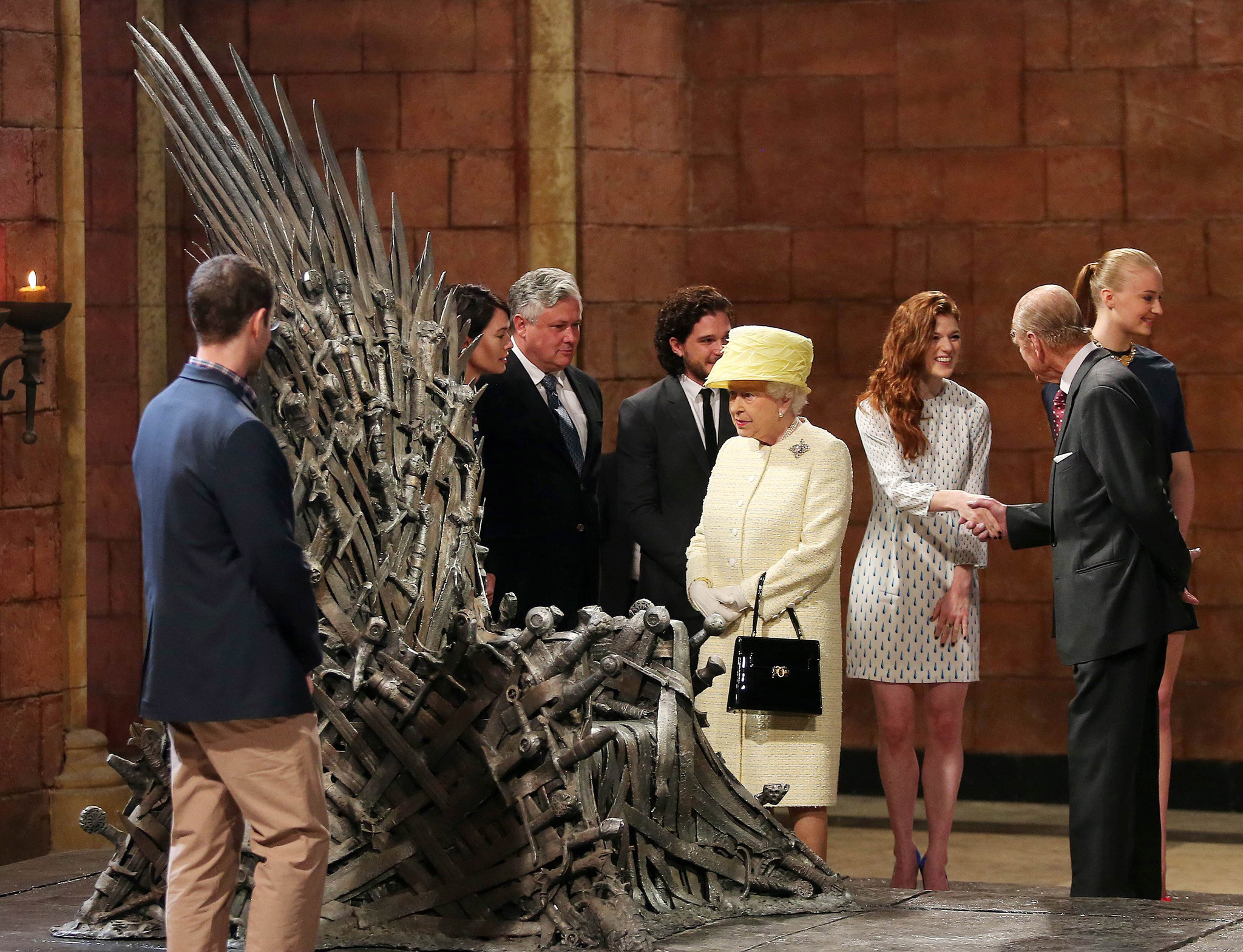 Queen Elizabeth II meets cast members of the HBO TV series 'Game of Thrones' Lena Headey and Conleth Hill while Prince Philip, Duke of Edinburgh shakes hands with Rose Leslie as they views some of the props including the Iron Throne on set in Belfast's Titanic Quarter on June 24, 2014 in Belfast, Northern Ireland.