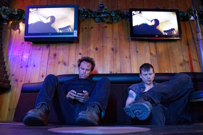 Walton Goggins and Kevin Rankin check their smart phones between scenes of the 