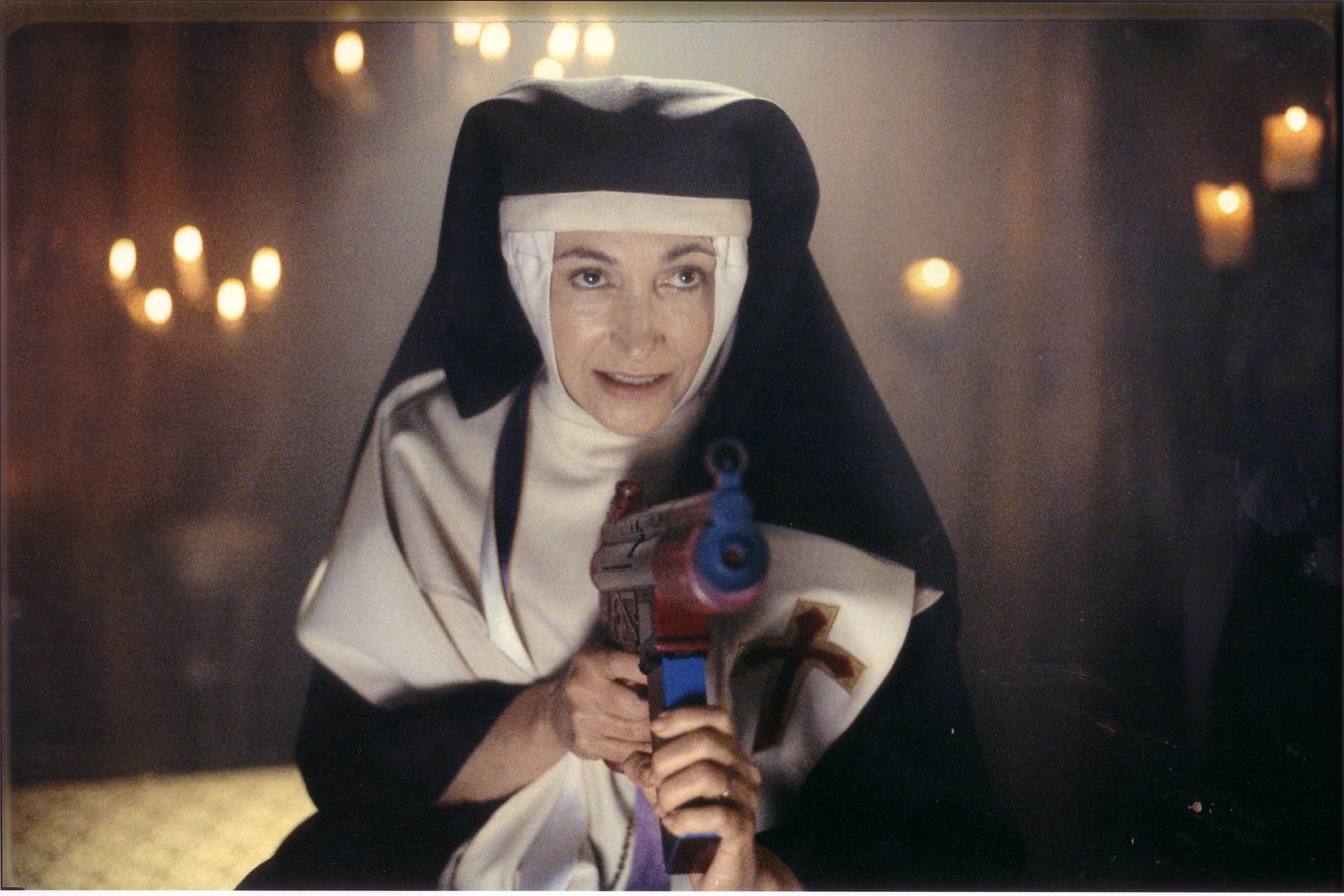 Sister Gloria shooting Holy Water from an Uzi Supersoaker - 