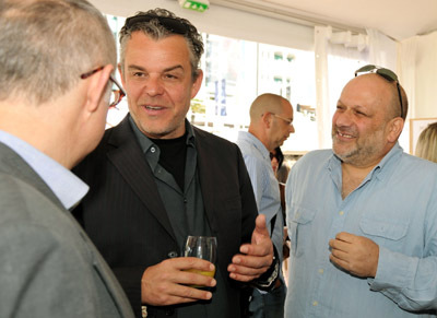 Director Eran Riklis (R) and actor Danny Huston (C) talk to guests as they attend the Danny Huston Press Breakfast held at the Moet Salon, Baoli Beach during the 63rd Annual International Cannes Film Festival on May 14, 2010 in Cannes, France.