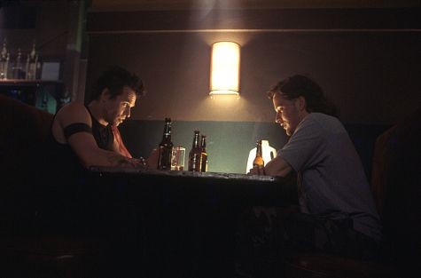 Danny (Val Kilmer) and Jimmy the Fin (Peter Sarsgaard) meet at a bar to discuss Danny's plan.