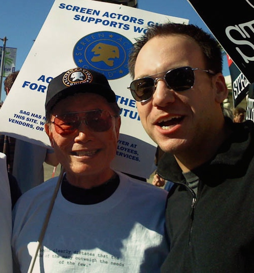 Stephen Scaia picketing with George Takei during the WGA Strike.
