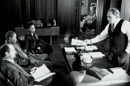 Morewitz (Gene Wolande), Danny (Samuel L. Jackson) and his wife (Regina Taylor), listen to the D.A. (Jack Shearer) spell out the charges in THE NEGOTIATOR.