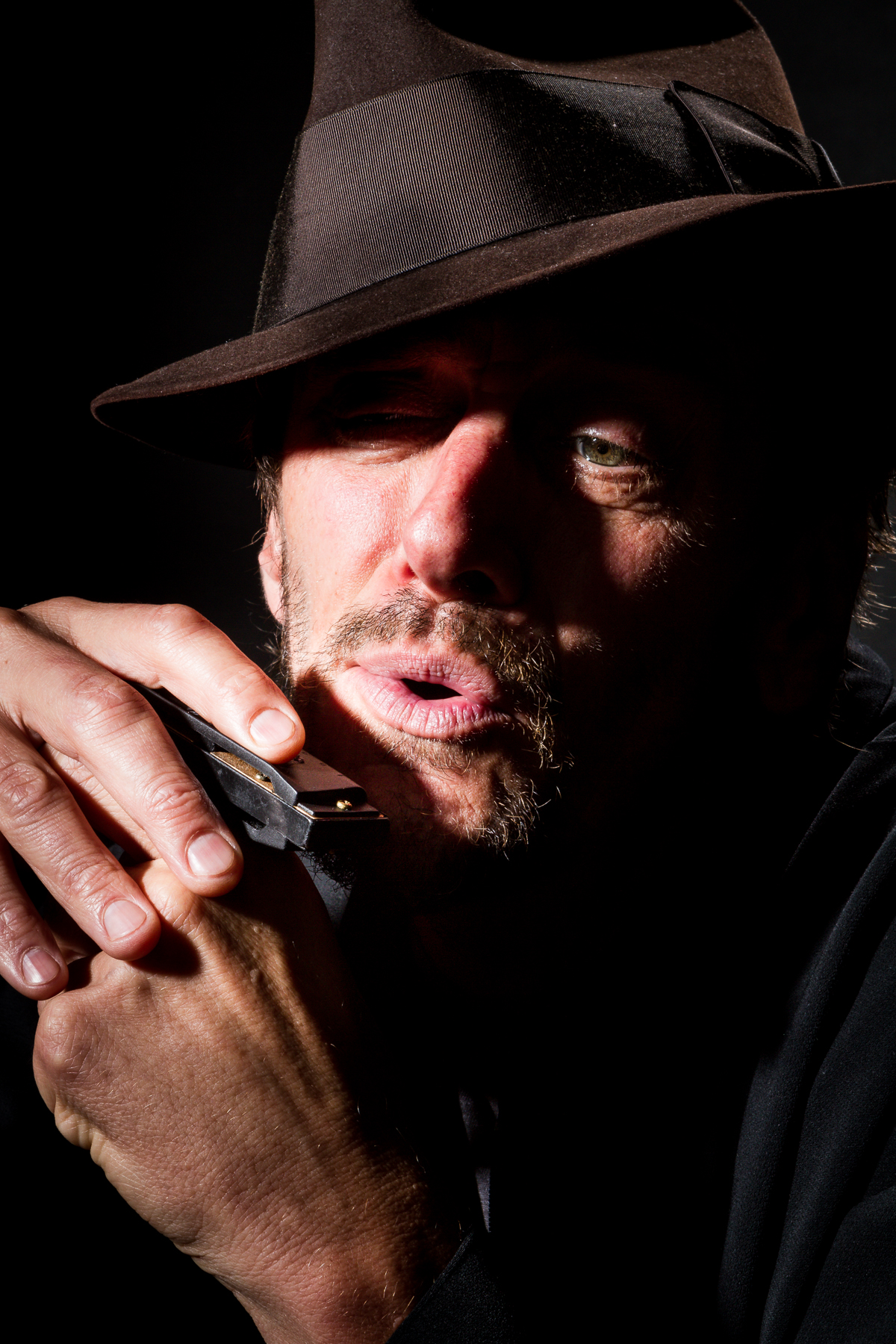 Sommers playing his harmonica as The Bluesman in his first true story one-man play 