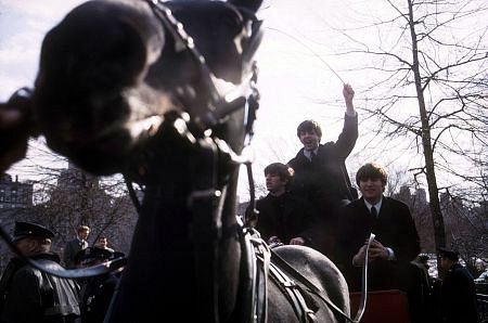 The Beatles ( Ringo Starr, Paul McCartney, John Lennon on a horse carriage ride. Paul is the only one standing)