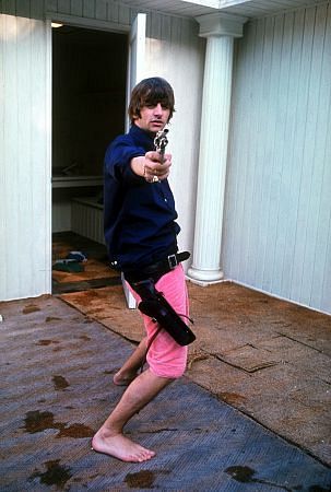 The Beatles (Ringo Starr playing with his gun pointing at the photographer), 1964