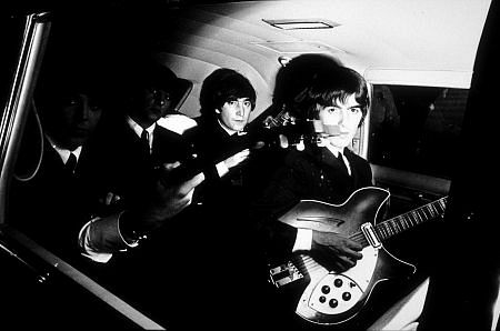 The Beatles (Paul McCartney, Ringo Starr, John Lennon, & George Harrison) inside the car with their guitars. c. 1964