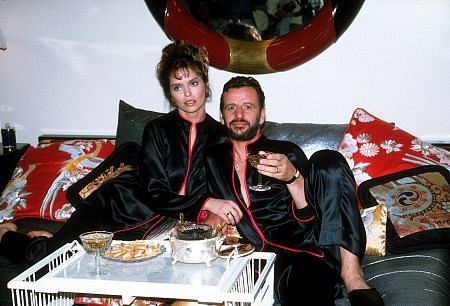 Ringo Starr and wife Barbara Bach in bed with some snacks.