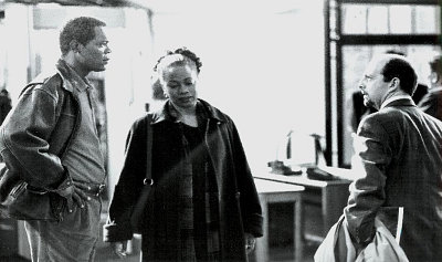 Danny (Samuel L. Jackson) and his attorney Morewitz (Gene Wolande) face off as his wife (Regina Taylor) watches in THE NEGOTIATOR.