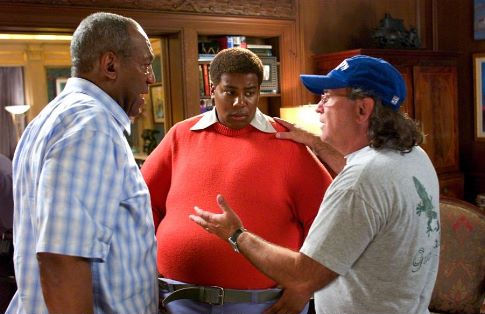 Bill Cosby and director Joel Zwick review a scene with Kenan Thompson on the set of FAT ALBERT.