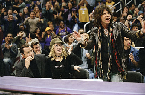 Chili Palmer (JOHN TRAVOLTA), Edie (UMA THURMAN), and Aerosmith frontman STEVEN TYLER take in a Lakers game courtside in MGM Pictures' comedy BE COOL.