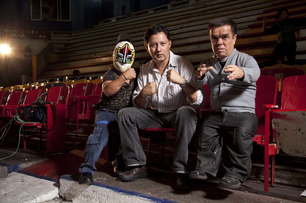 Director Carlos Avila (center) with mini-wrestlers Mascarita Sagrada (masked, left) and Gulliver (right) on the set of 