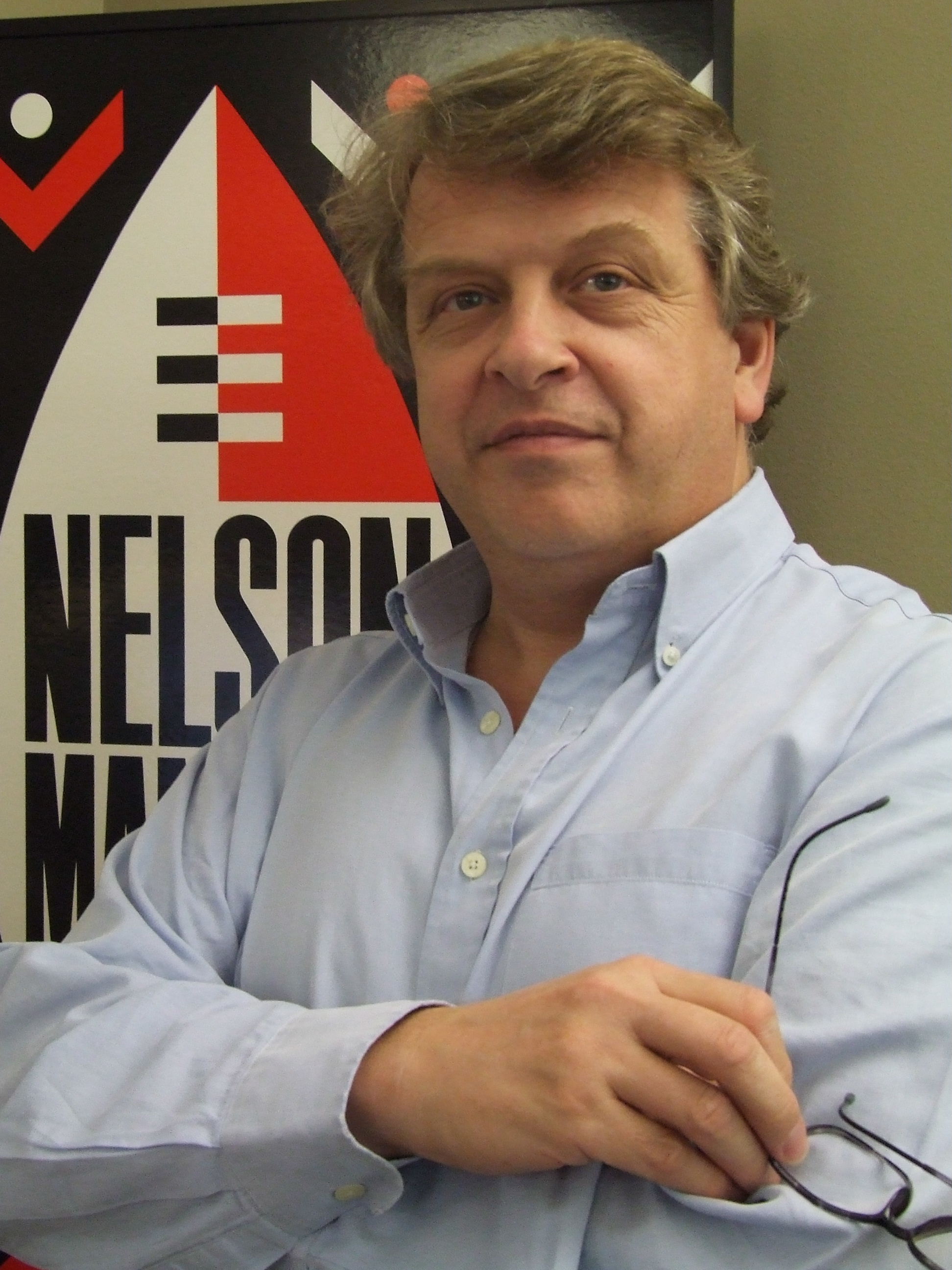 Tony Hollingsworth in front of a poster for the first Nelson Mandela concert in 1988