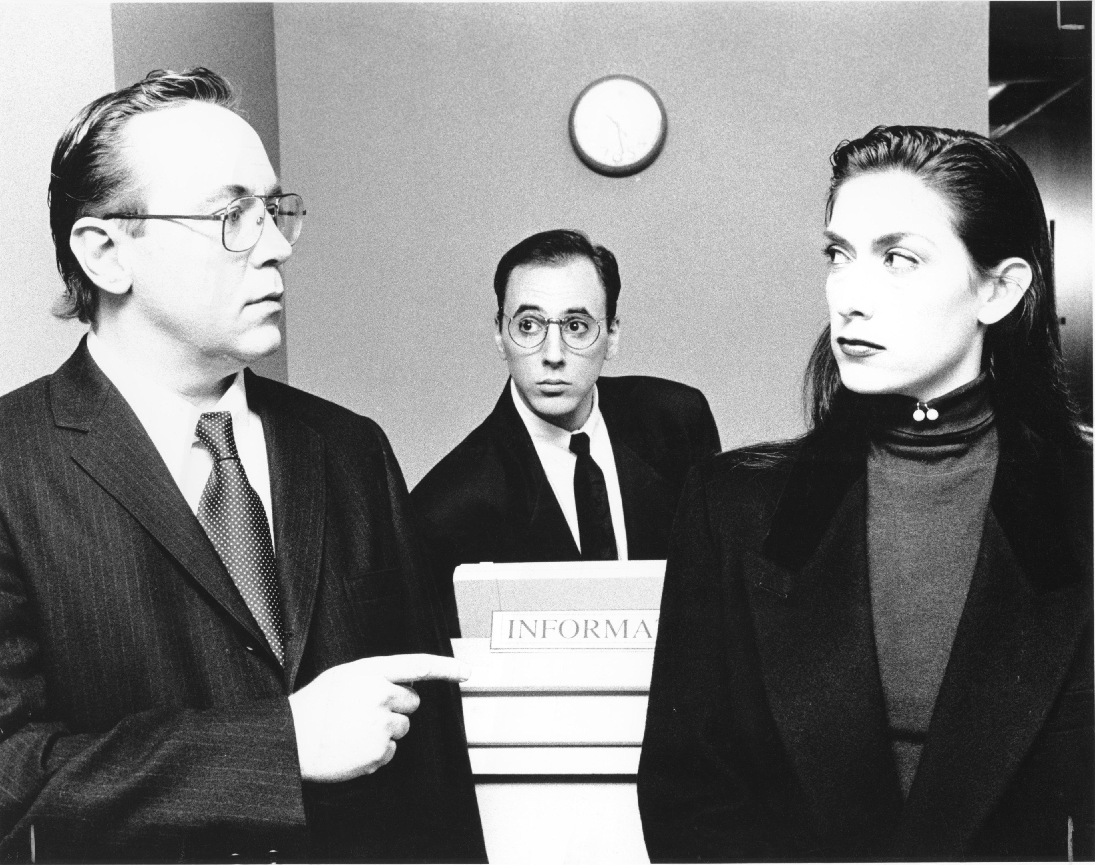 The Service Clerk (Jeff Corveau) easdrops on a conversation held between The Head Clerk (Robert Jodka) and Martha Morgan (Robin Reck) in a scene from filmmaker Angel Connell's 