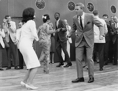 Steve McQueen dancing with Lucy Johnson at a Democratic fundraiser as photographer William Claxton photographs the scene from the other side of the dance floor circa 1966