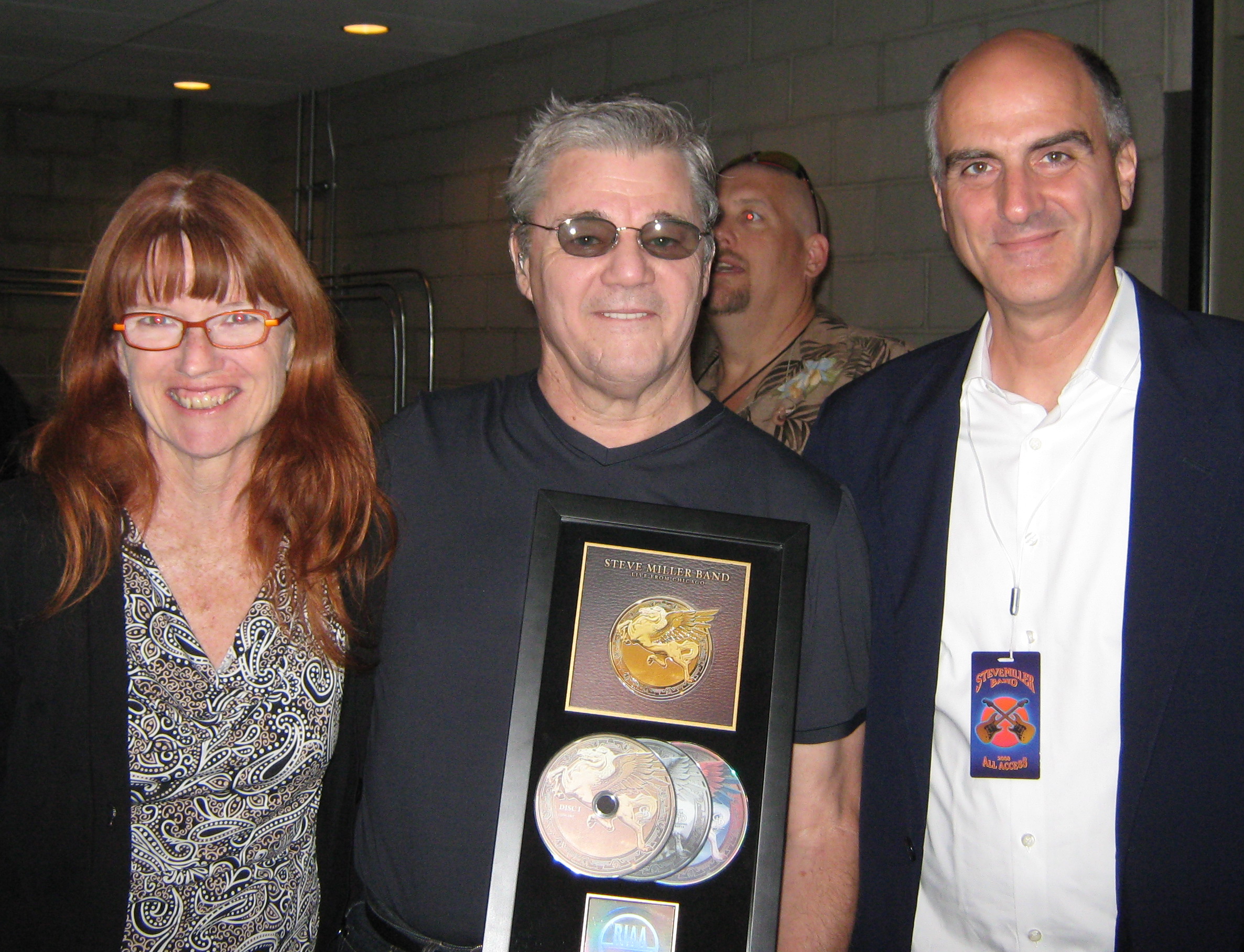 Judi Kerr, PR and Jack Gulick, Producer present Steve Miller with RIAA - Certified Gold Plaque Award for Steve Miller 