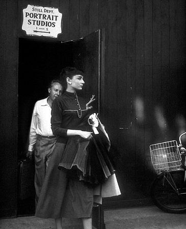 33-1121 Audrey Hepburn helped by photographer Bud Fraker leaving photo gallery C. 1956