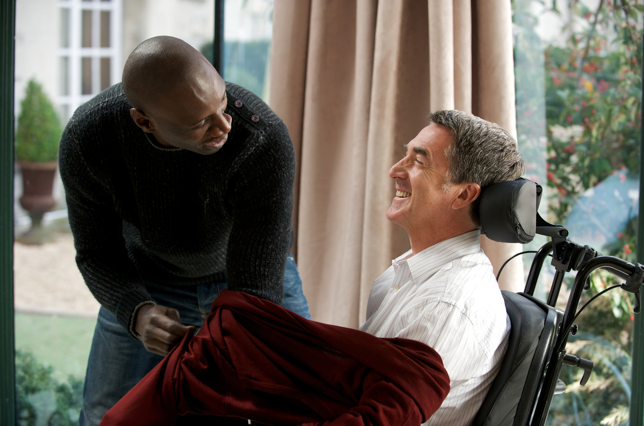 Still of François Cluzet and Omar Sy in Nelieciamieji (2011)