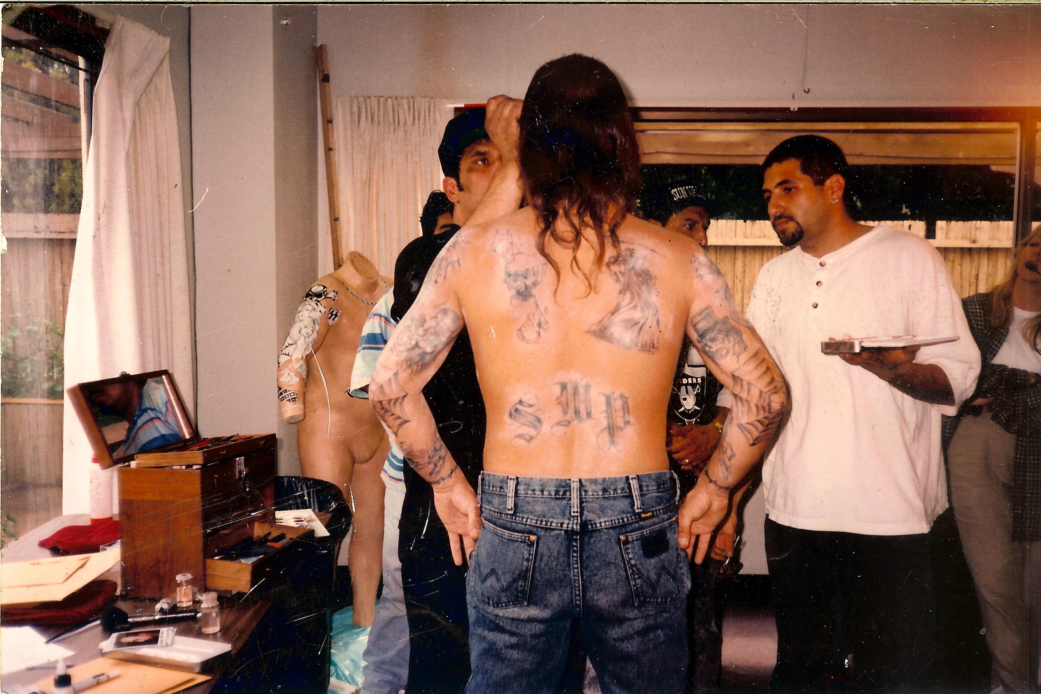 Ken Diaz and Jay Wejebe apply final touches to temporary tattoos on Kevin Gage as Waingro in 