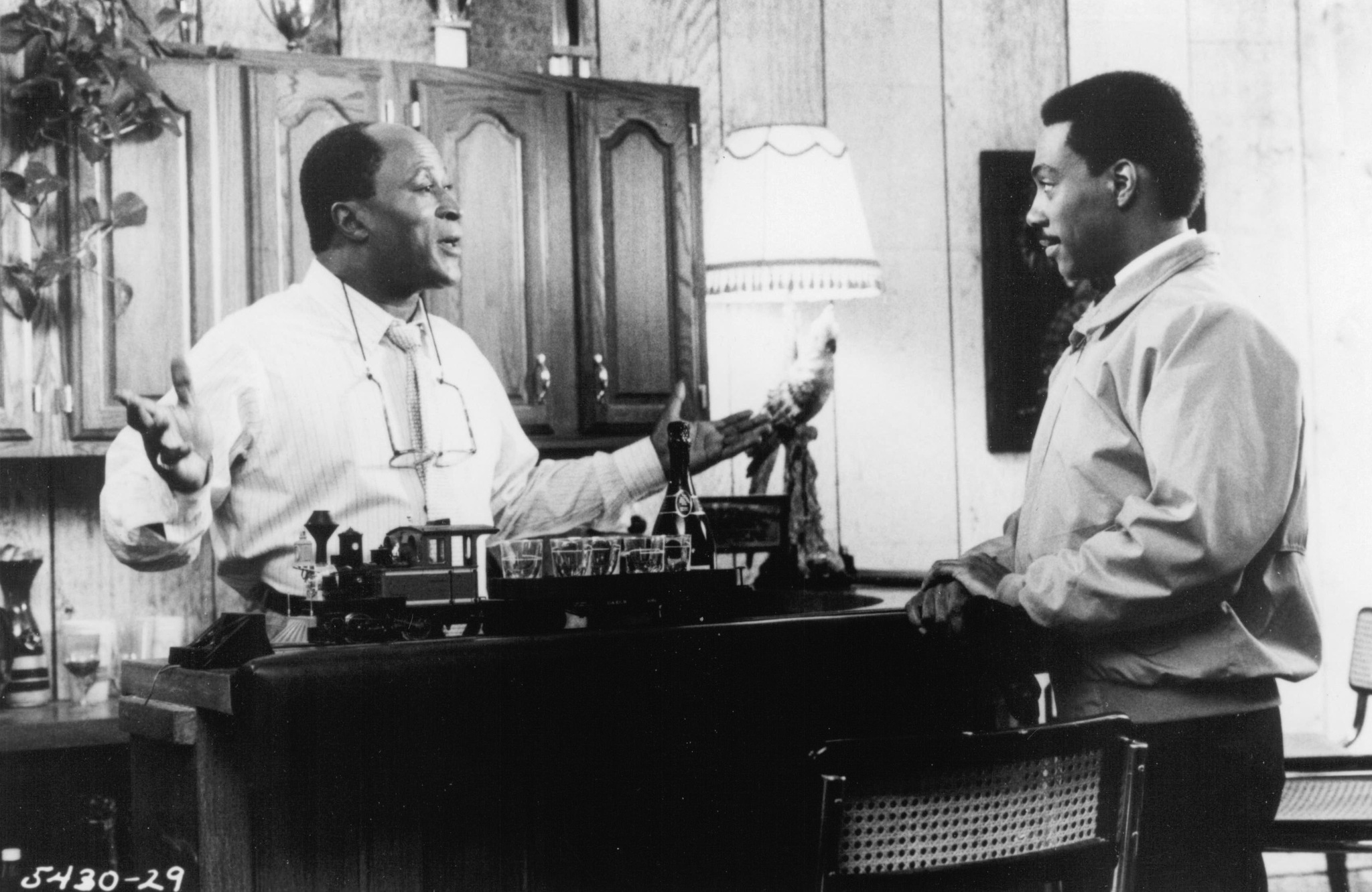 Still of Eddie Murphy and John Amos in Coming to America (1988)
