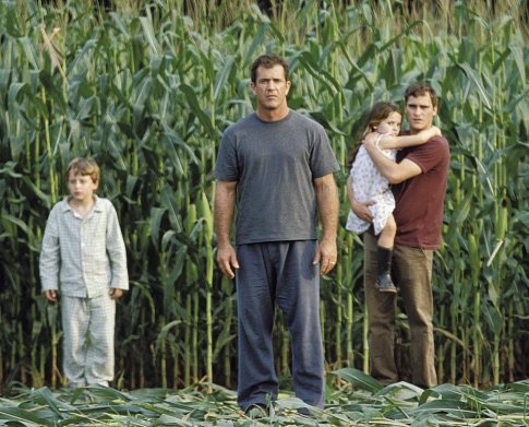 Graham Hess (Mel Gibson, center left), along with his son, Morgan (Rory Culkin, left), his daughter, Bo (Abigail Breslin, center right), and his brother, Merrill (Joaquin Phoenix, right), investigate the strange occurrence.