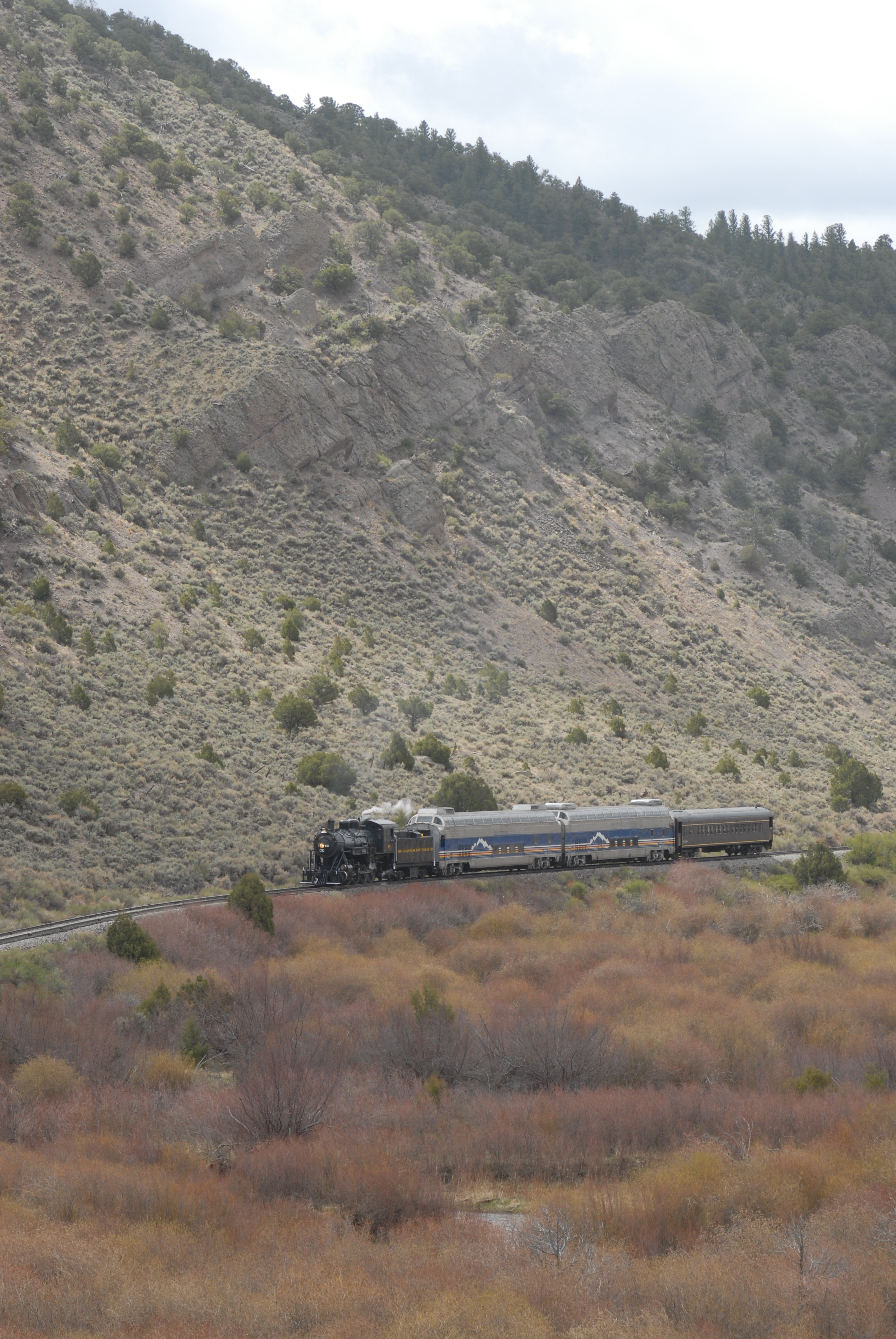 2008. San Luis & Rio Grande #18 and train is dwarfed by Cucharas Range foothills east of Ft. Garland.