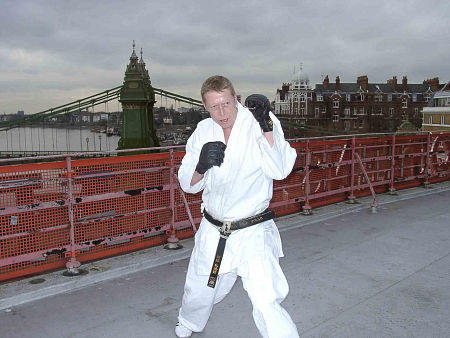 Adrian Rayment prepares to attack on a roof-top near Hammersmith bridge, London, UK.