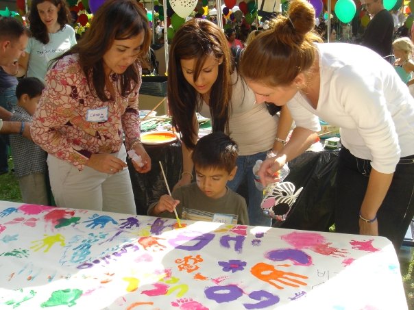 Deidra Sarego at The Art of Elysium NICU event teaching children how to paint.