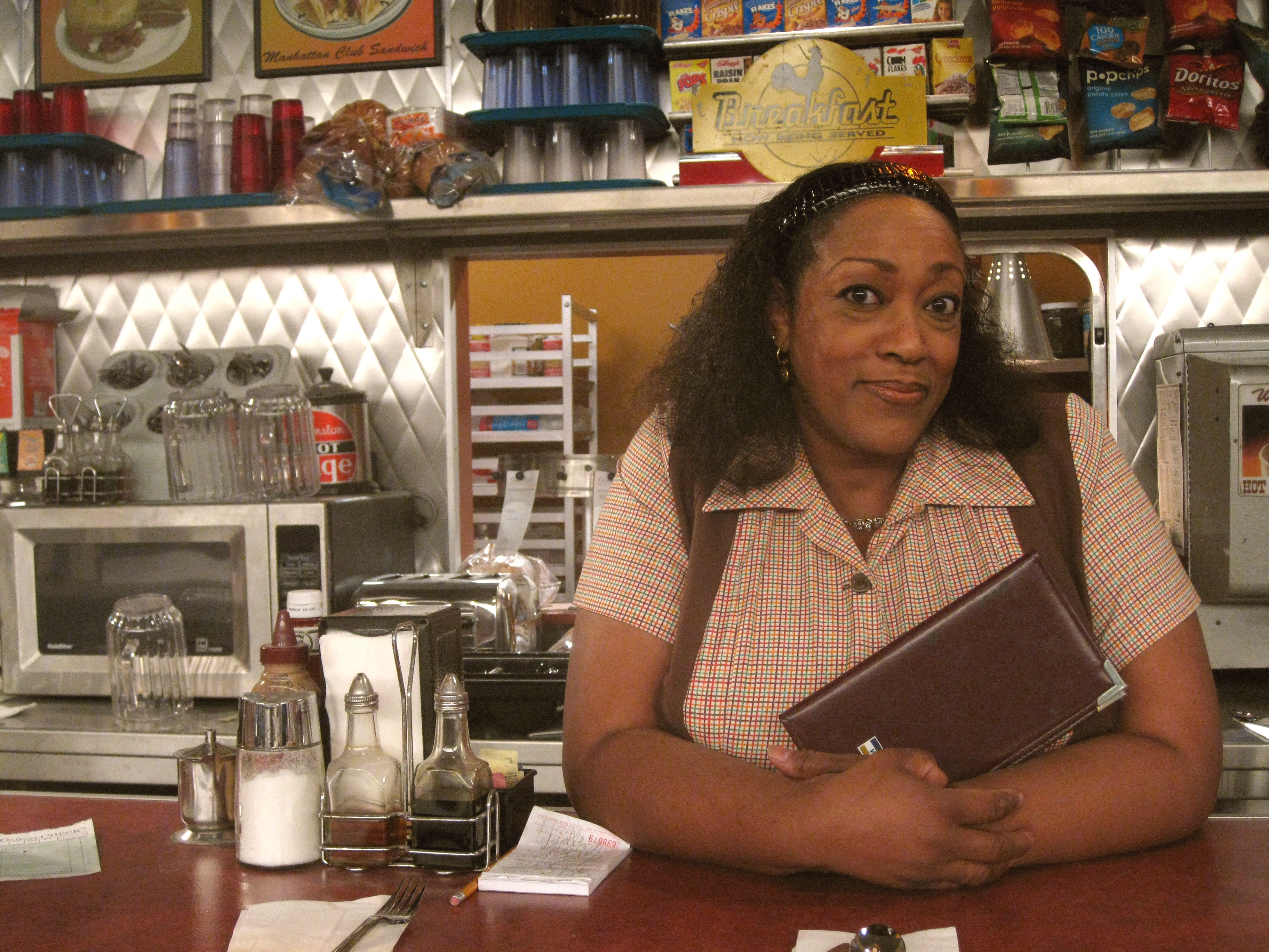 Rules of Engagement's Doreen behind the Island Diner counter