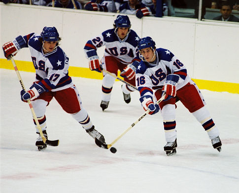 Jack O'Callahan (Michael Mantenuto, left), Buzz Schneider (Billy Schneider, center), and Mark Pavelich (Chris Koch, right) chase the puck.