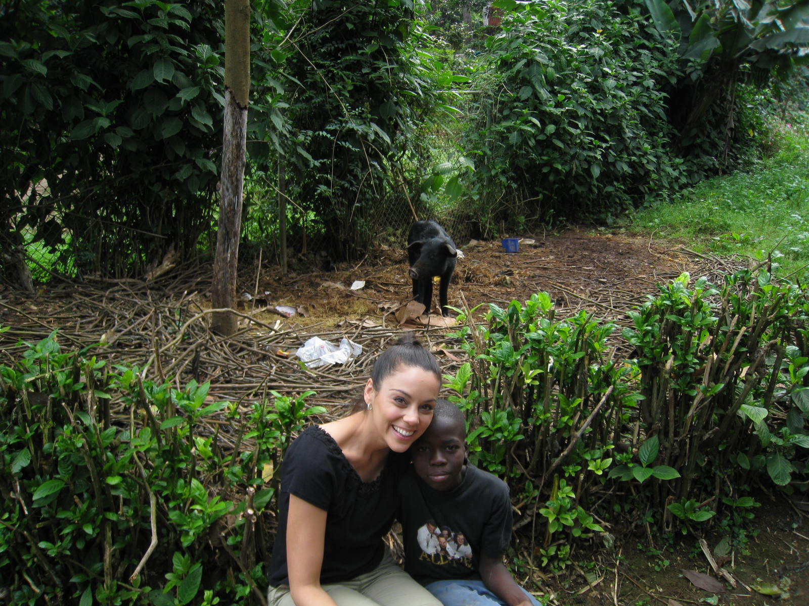 Tessa Munro with a Haitian boy, Samuel, and a cute pig (behind them) in the mountains of Haiti (January, 2012). Humanitarian work and Haiti are important to her.