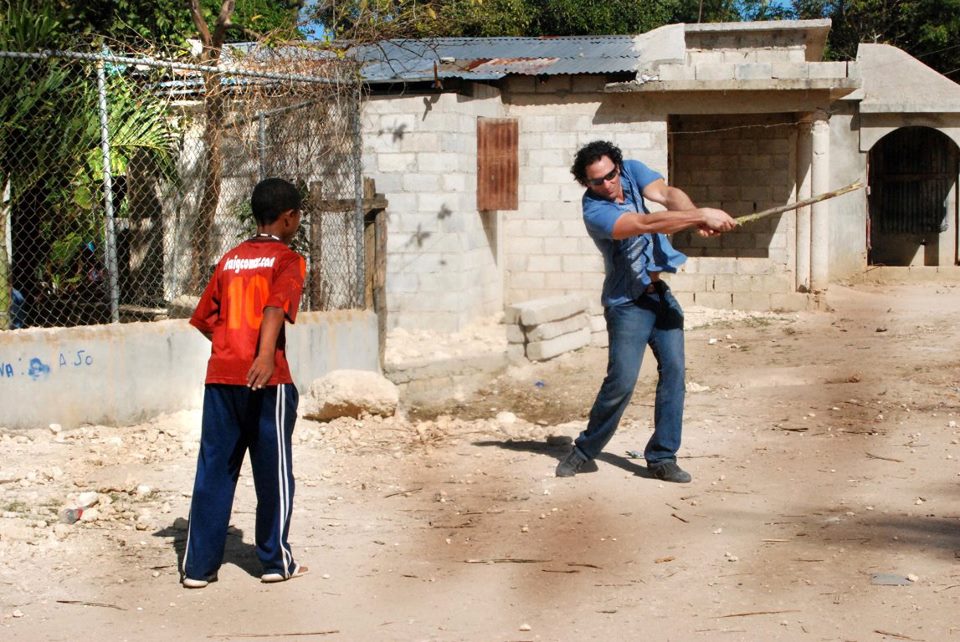 Joe Floccari taking a break from shooting a documentary in the Dominican Rebublic... Playing some stick ball in a Barrio.