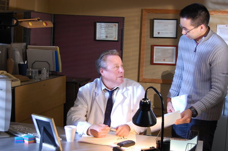 John Heard (starring as Dr. Alan Shearson) converses with director Russ Emanuel in P.J., a Russ Emanuel film.