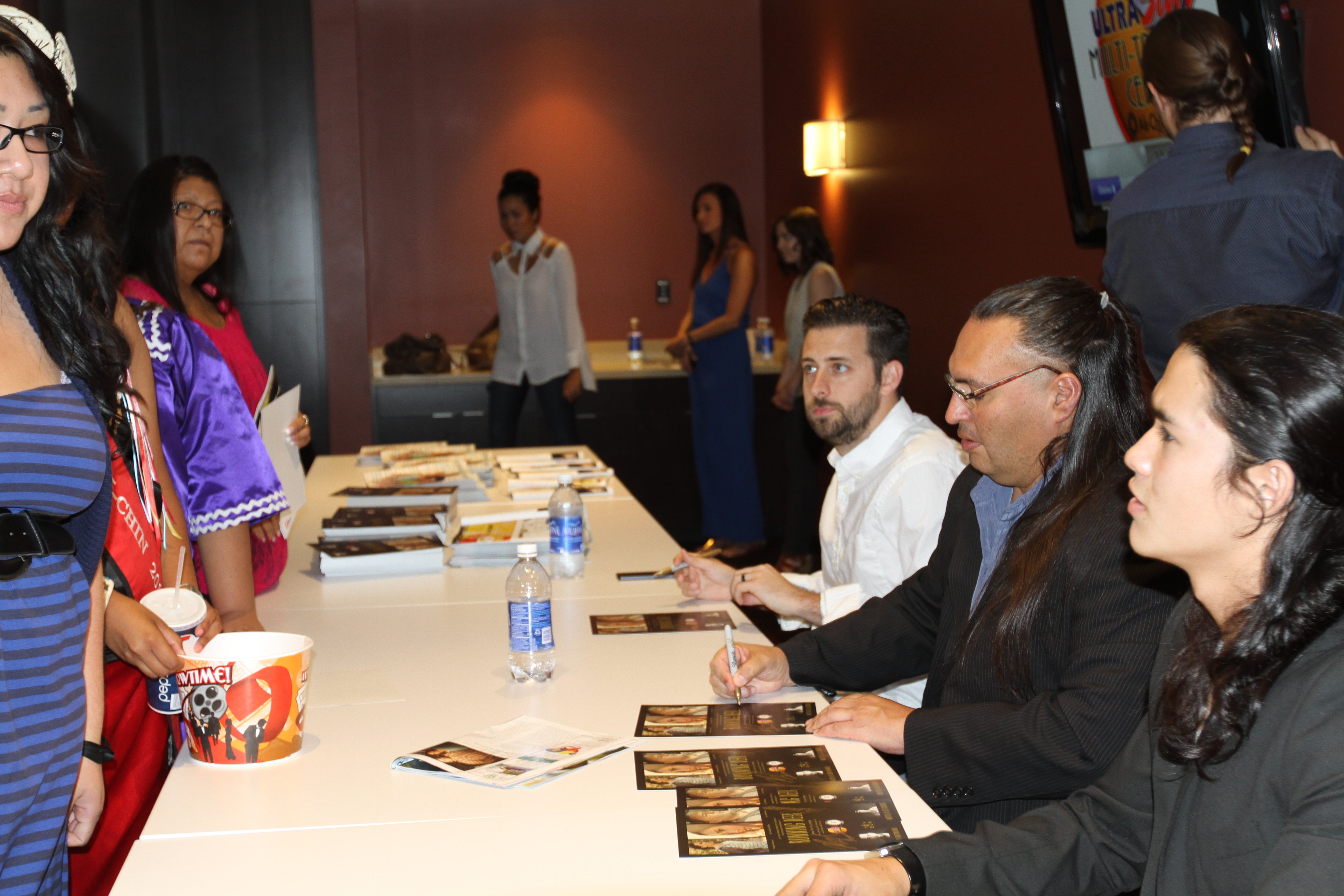 Booboo Stewart, Jon Proudstar and Brent Ryan Green autographing posters following the premiere of Running Deer